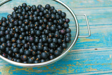 Fresh black currant on a wooden background, top view