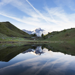 snow capped mountain reflected in water of small lake near col de vars in french haute provence