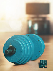 Dumbbells in the foreground, in the background TV. Concept active rest, overcome laziness