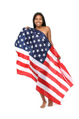Hübsche junge Frau mit der Fahne der Vereinigten Staaten von Amerika lacht vor weißem Hintergrund
