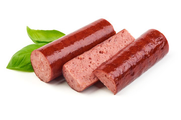 Sliced smoked sausage with fresh basil leaves, isolated on white background. Close-up.