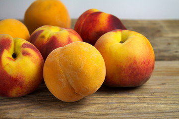 Naklejka na ściany i meble A group of ripe peaches on wooden surface