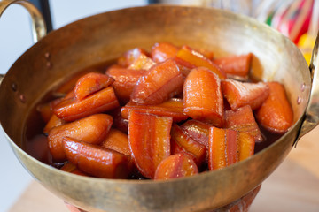 Cultivated banana in syrup in brass pan
