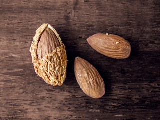 Almond nut in shell and shelled on wooden background