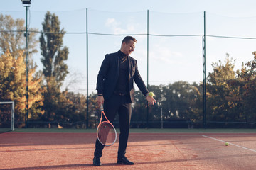 Fototapeta na wymiar Businessman holding tennis racket ready to serve