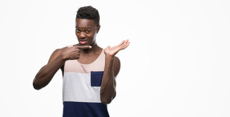 Young african american man very happy pointing with hand and finger