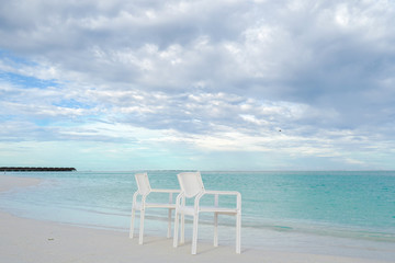 Summer concept , White chair on the beach white sand and turquoise sea color at maldives on the weekend holidays