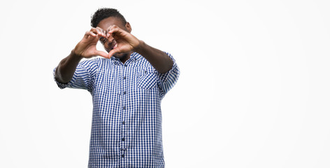 Fototapeta premium Young african american man wearing blue shirt smiling in love showing heart symbol and shape with hands. Romantic concept.