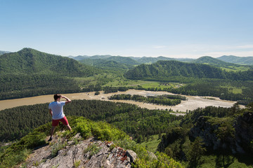 Fototapeta na wymiar Man standing on top of cliff in summer beauty day in Altai mountains
