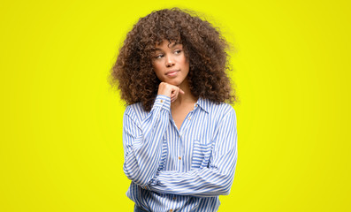 African american woman wearing a stripes shirt serious face thinking about question, very confused...