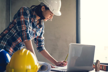 Architect & Engineer working drawing document about project planning and progress of work schedule on the home building construction site