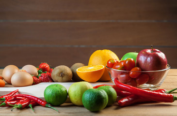 Healthy concept with mixed fruits and vegetables on wooden background