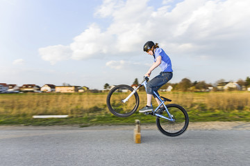 boy jumping with his dirk bike over a barrier at the street