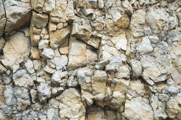 Pebble stones in a rocky wall. Natural background of a rocky stone wall