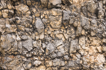 Pebble stones in a rocky wall. Natural background of a rocky stone wall