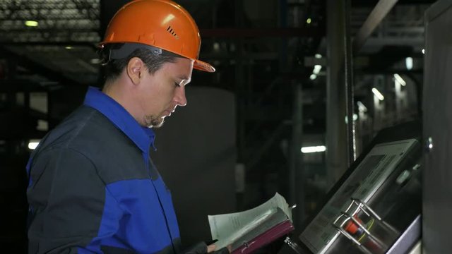 Operator monitors control panel of production line. Manufacture of plastic water pipes of the factory. Process of making plastic tubes on machine tool with the use of water and air pressure.