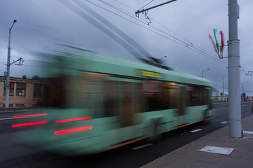 Fototapeta na wymiar Movement of a blurred trolleybus at dusk along the street. 