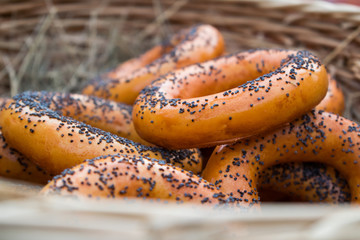Dryers, bagels, golden baked and sweet round buns with poppies in the form of rings in wicker baskets made from a vine. Appetizing traditional flour products, dessert and snack for tea and drinks