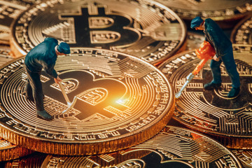 macro miner figurines working on group of bitcoins. virtual cryptocurrency mining concept