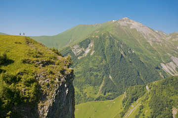 People near a cliff in the Caucasus Mountains in Georgia 