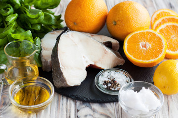 Raw cod, oranges, ingredients for cooking