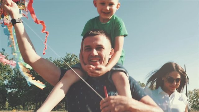Happy family, mom, dad and son are walking in nature, launching an air snake. Stock footage.