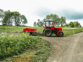 Fototapeta premium Red Tractor near rural road