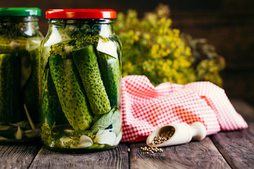 canned cucumbers in a jar on a wooden background, harvesting vegetables, pickles
