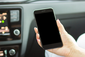 girl sitting in the car holding a smartphone in her hand, close-up