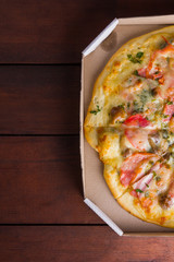 Italian pizza on wooden boards, pizza with bacon, dried tomatoes and Parmesan cheese, Italian cuisine, appetizing dish with meat and cheese, art