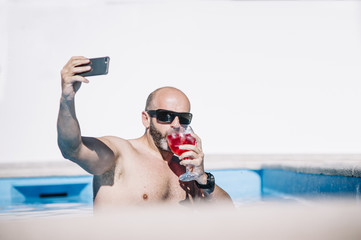 attractive man indoors pool with red drink