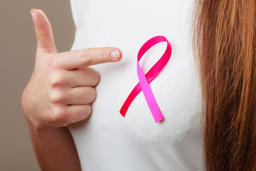 Pink ribbon on woman chest to support breast cancer cause