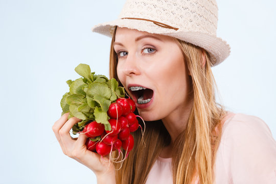 Happy woman biting radish