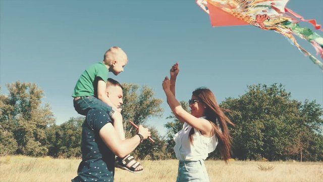 Happy family, mom, dad and son are walking in nature, launching an air snake. Stock footage.