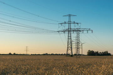 high voltage power line with pylon at a agricultural field 