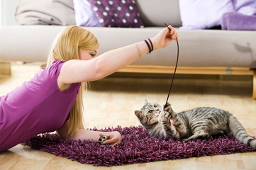 Junge Frau spielt mit Katze