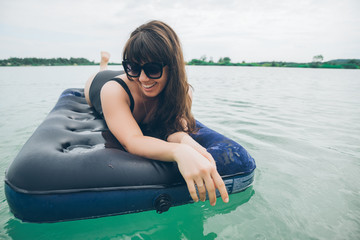 woman on mattress swimming in azure water