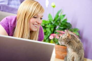 Fototapeta premium Junge Frau mit Katze im Wohnzimmer