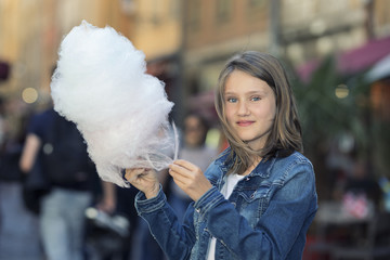 Outdoor portrait of beautiful girl with cotton candy