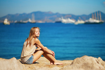 Fototapeta na wymiar Young woman enjoying her vacation by the sea