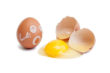 The egg on which is painted a face and a broken raw egg. Shell, yolk, protein isolated on a white background