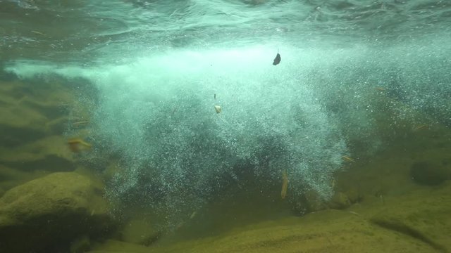 Flowing creek with air bubbles underwater and some fish (Eurasian minnow), La Muga, Girona, Alt Emporda, Catalonia, Spain

