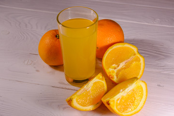Oranges and glasses with orange juice on a wooden table
