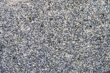 A gray marble wall into a large black dot. Textural background. Wallpaper