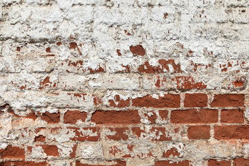 vintage red brick wall on the building with white plaster peeling off from time