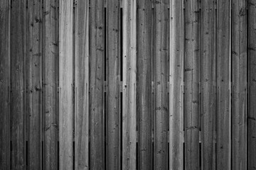Fototapeta premium Full frame background of an unpainted wood board wall in black and white with vignette