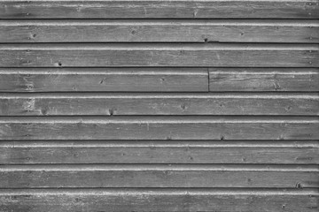 Full frame background of an old and faded wood board wall in black and white