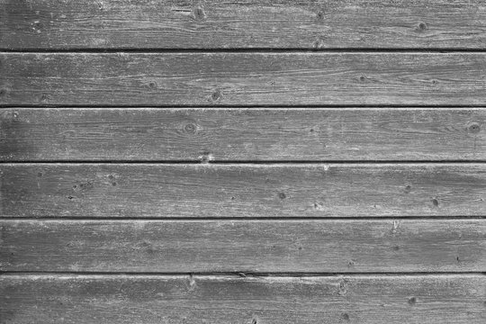 Full frame background of an old and faded wood board wall in black and white