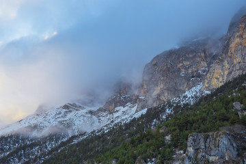 The top of the mountain in the snow and covered with clouds