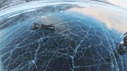 Family is having fun on beautiful ice in cracks. Father mother son and daughter funny fight on ice, make sandwich and rest. Man, woman and children are resting on the lake of Baikal. - Powered by Adobe